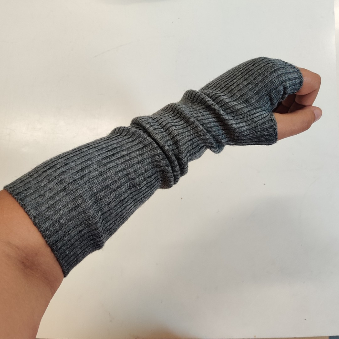 Ribstrikkede håndledsvarmere i lysegrå uld.