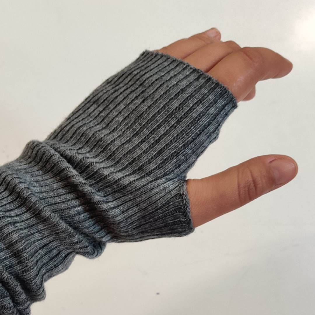 Ribstrikkede håndledsvarmere i lysegrå uld.