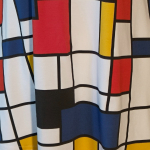 Sakura Bluse - Bauhouse. A-formet bluse fra Amamiko med markant geometrisk print i rød, gul og blå på en klassisk hvid baggrund