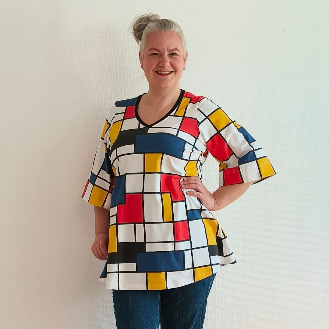 Sakura Bluse - Bauhouse. A-formet bluse fra Amamiko med markant geometrisk print i rød, gul og blå på en klassisk hvid baggrund