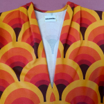 Sakura Bluse - Retro Rainbow fra Amamiko. En orange peplum bluse med Retro-charmerende elegance og v-hals