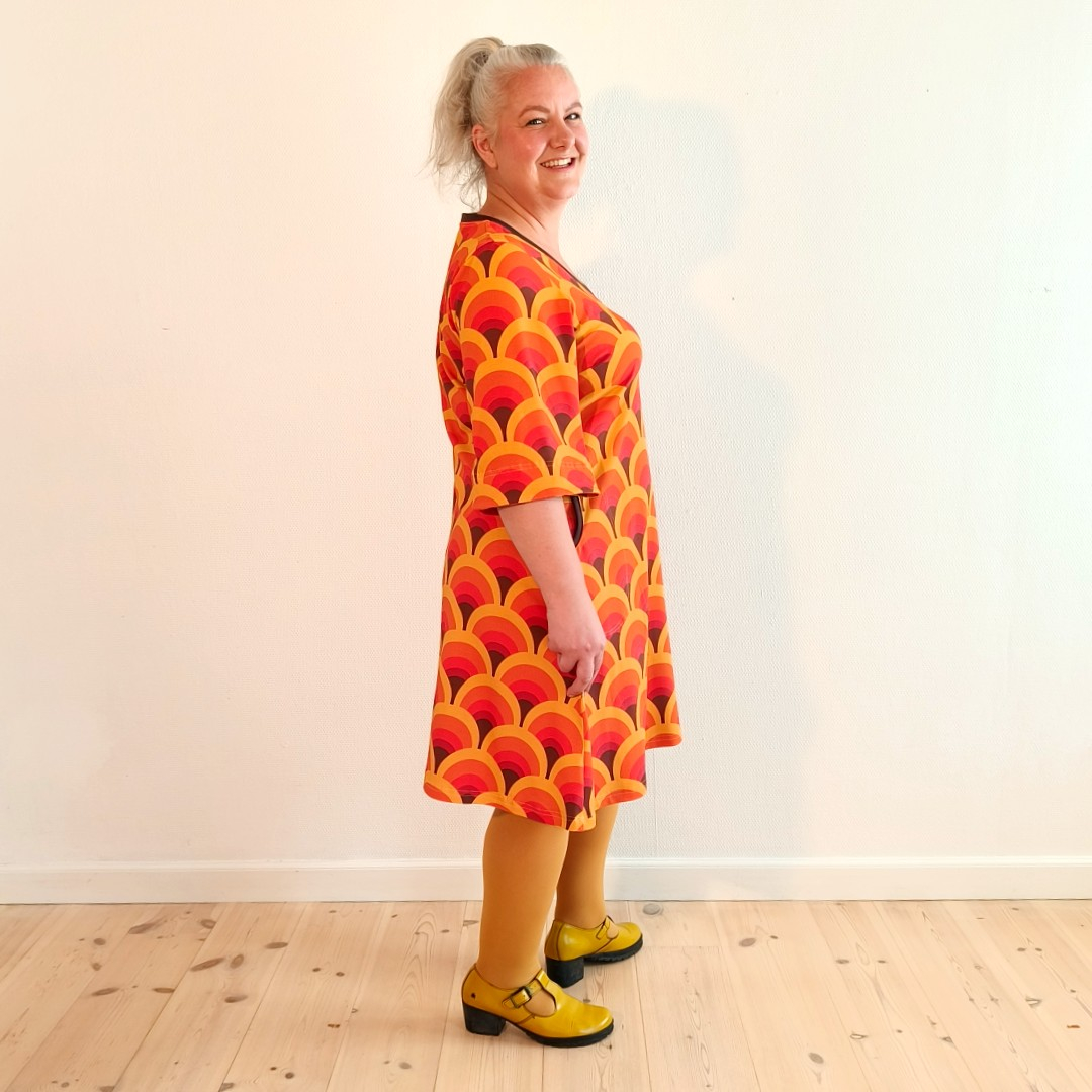 Orange A-formet kjole med retro mønster og dybe lommer fra Amamiko