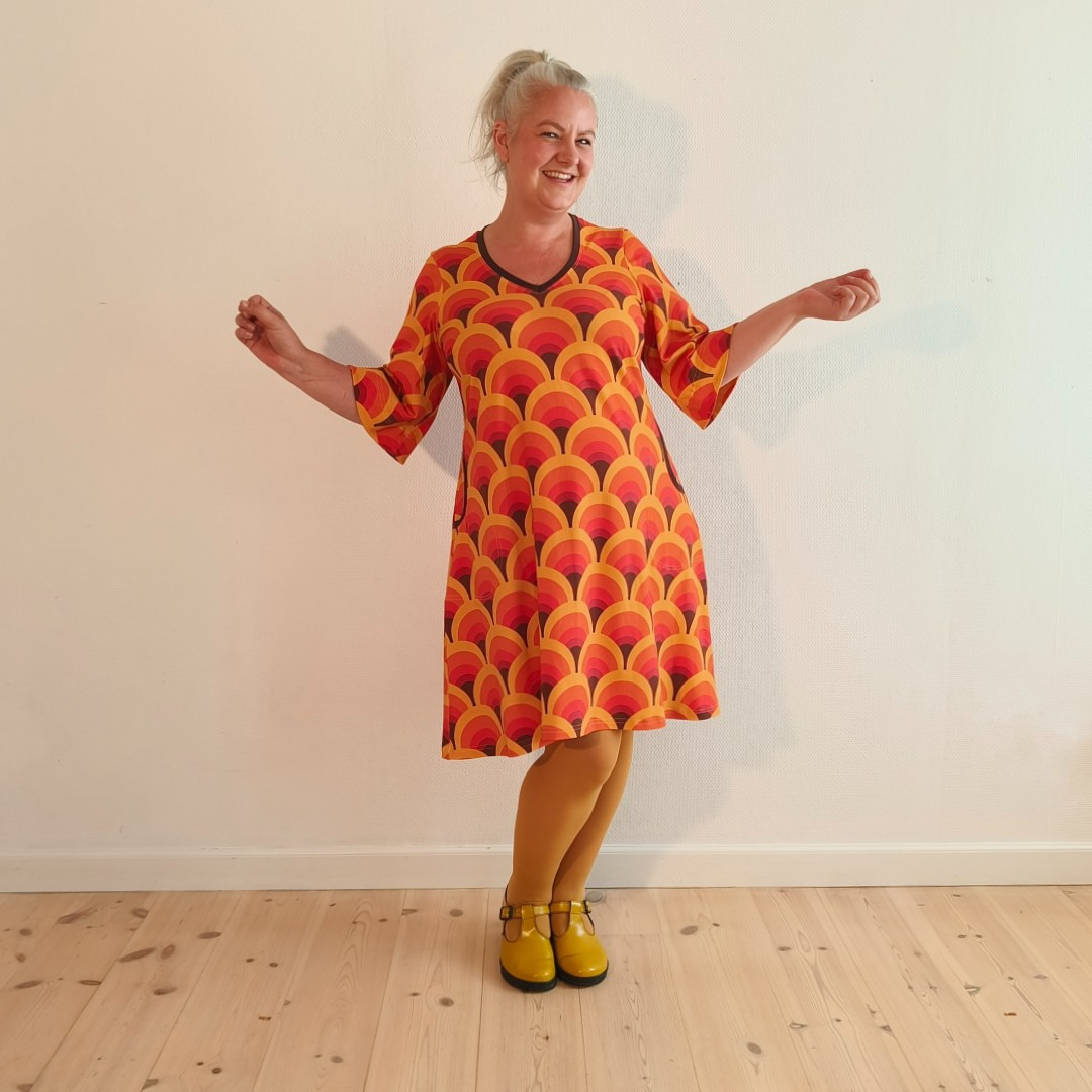 Orange A-formet kjole med retro mønster og dybe lommer fra Amamiko