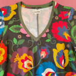 Sort A-formet kjole med farverige blomster og dybe lommer fra Amamiko