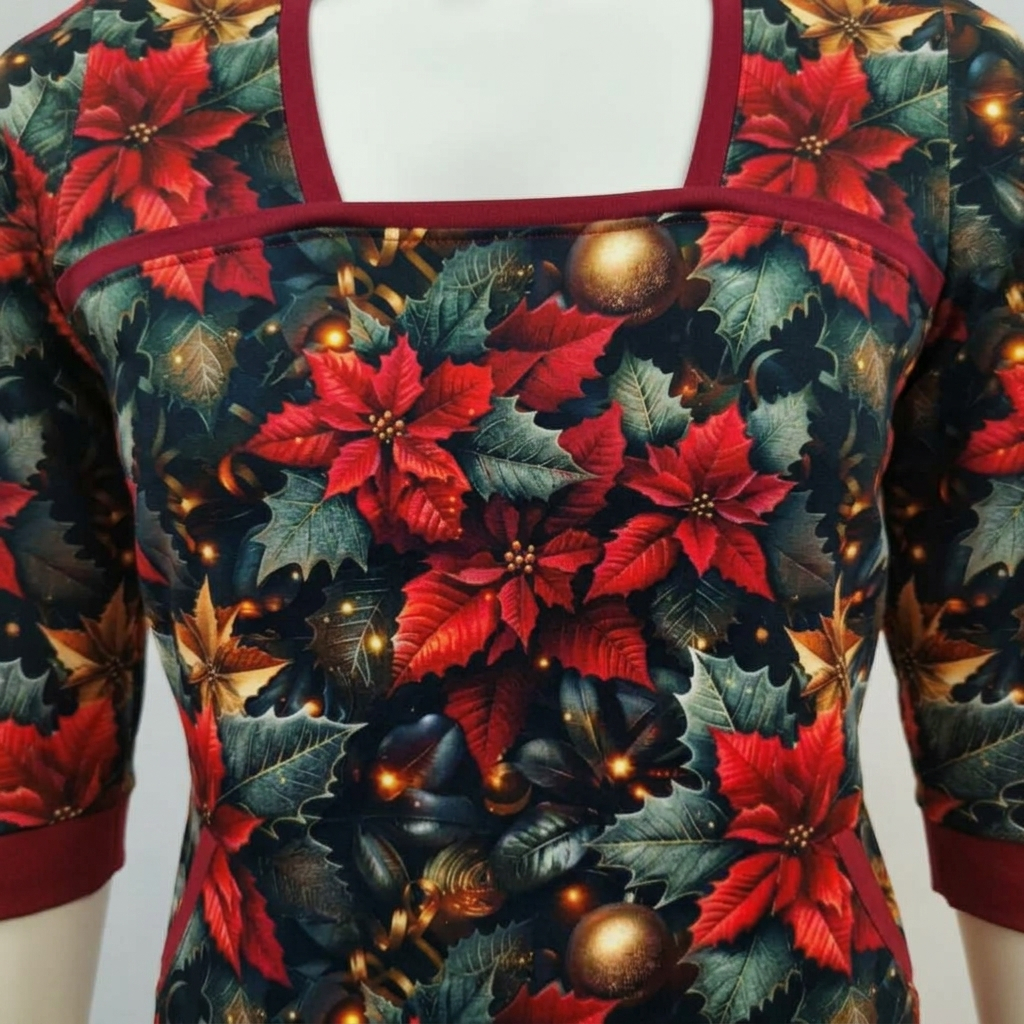 Genkei Christmas Flower julekjolen i blød økologisk bomuldsjersey. Rødt og gyldent julemotiv, firkantet udskæring, praktiske lommer og et flatterende skørt.
